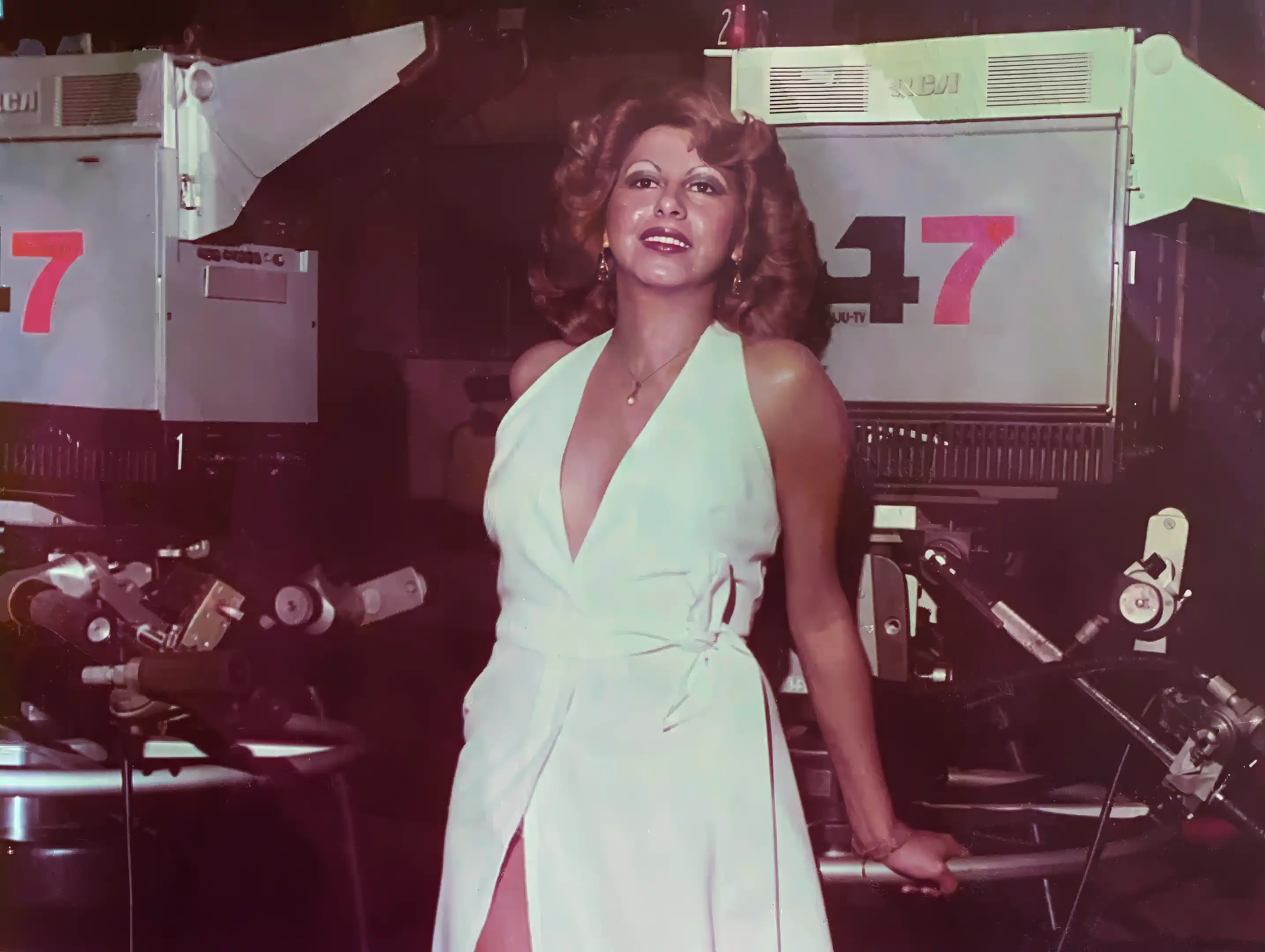 An old image of Sonia from when she was young, in a white dress wearing a fur coat.