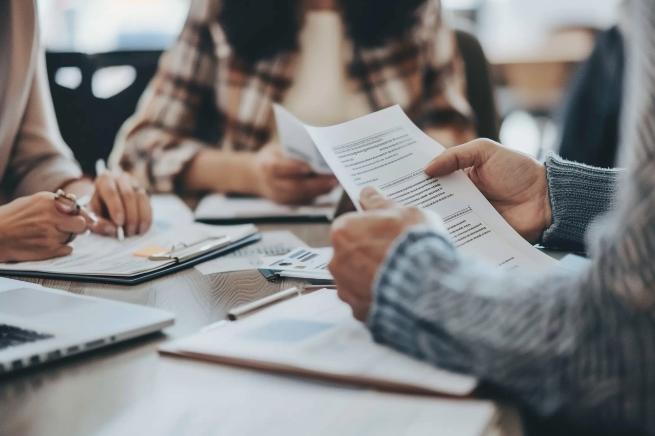 A close-up of hands holding and reviewing documents, symbolizing the process of checking eligibility criteria and preparing for application.